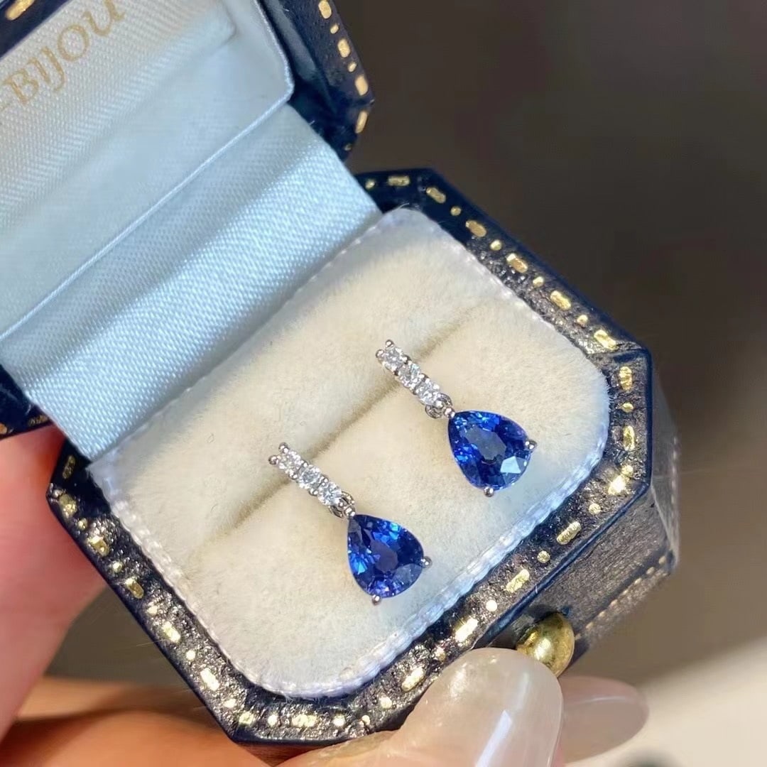 14K GOLD 0.90 CT VIVID BLUE NATURAL SAPPHIRE & DIAMOND EARRINGS: Ref:230622565 Gold Content:14K Gold Main Gemstone:Sapphire Number of stones:2 Shape:Pear Carat Weight:0.90ct Color:Vivid Blue Treatment:Natural Cut Grade:G Adjacent Gemstone 2 : Diamond Shape:
