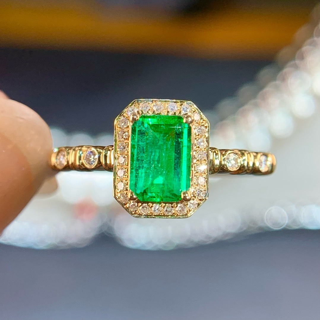 14K GOLD 0.69 CTW VIVID GREEN NATURAL EMERALD & DIAMOND RING: Ref:230715253 Gold Content:14K Gold Ring Size:7.25US Main Gemstone:Emerald Number of stones:1 Shape:Octagonal Carat Weight:0.58ct Color:Vivid Green Treatment:Natural Cut Grade:G Adjacent Gemst