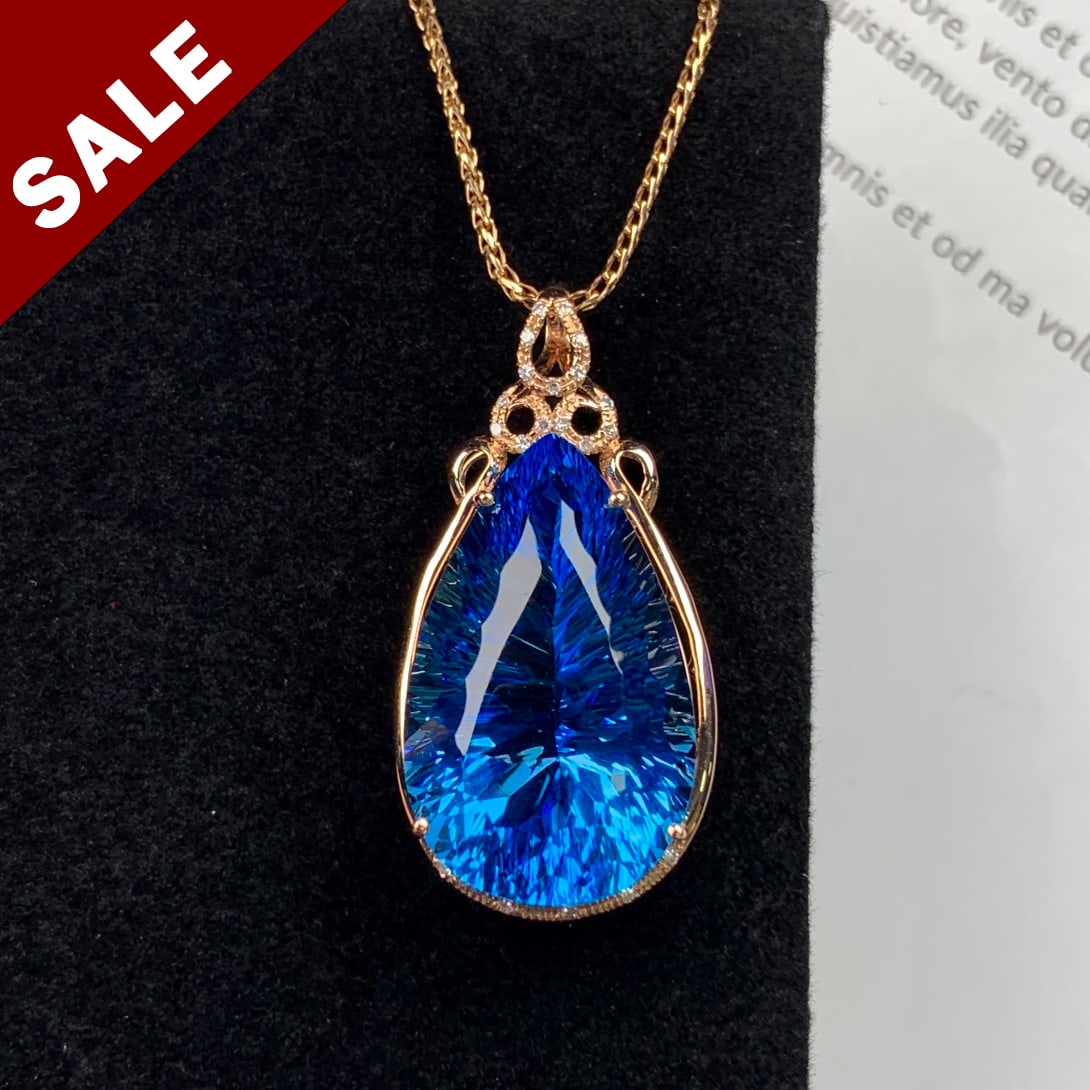14K ROSE GOLD 30.01 CTW NATURAL TOPAZ & DIAMOND PENDANT: Ref:230794014 Gold Content:14K Rose Gold Main Gemstone:Topaz Shape:Pear Carat Weight:29.95ct Color:Blue Treatment:Natural Cut Grade:G Adjacent Gemstone 2 : Diamond Shape:Round Carat Weight:0.0