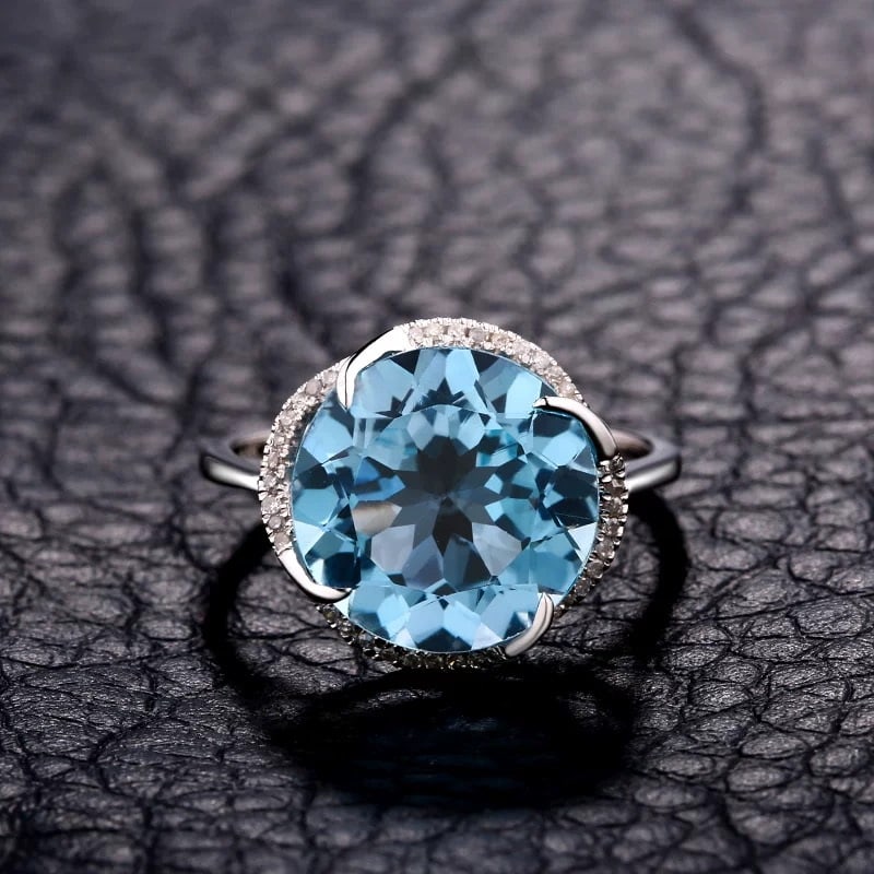 14K GOLD 7.17 CTW NATURAL TOPAZ & DIAMOND RING: Ref:230848044 Gold Content:14K Gold Ring Size:7.25US Main Gemstone:Topaz Number of stones:1 Shape:Round Carat Weight:7.09ct Color:Blue Treatment:Natural Cut Grade:G Adjacent Gemstone 2 : Diamo