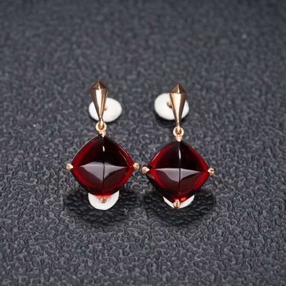 14k Gold 10.33 Ct Natural Garnet Earrings: Ref:231108232 // gold content:14k gold // main gemstone:garnet // shape:sugar-loaf // carat weight:10. 33ct // color:red // treatment:natural // Condition: New Low Estimate: 2100.00 High Estimate: 31