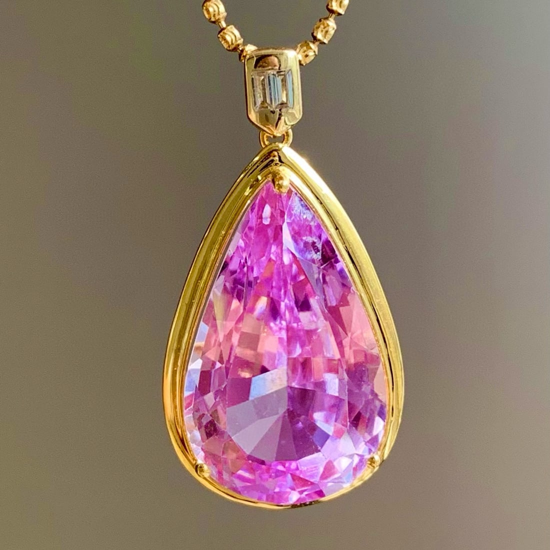 14k Gold 22.6 Ct Natural Kunzite & Solitaire Pendant( Without Chain ): Ref:231121031 // gold content:14k gold // main gemstone:kunzite // shape:pear // carat weight:22. 6ct // color:pinkish purple // treatment:natural // Condition: New Low Estimate: 4500.00 High Estimat