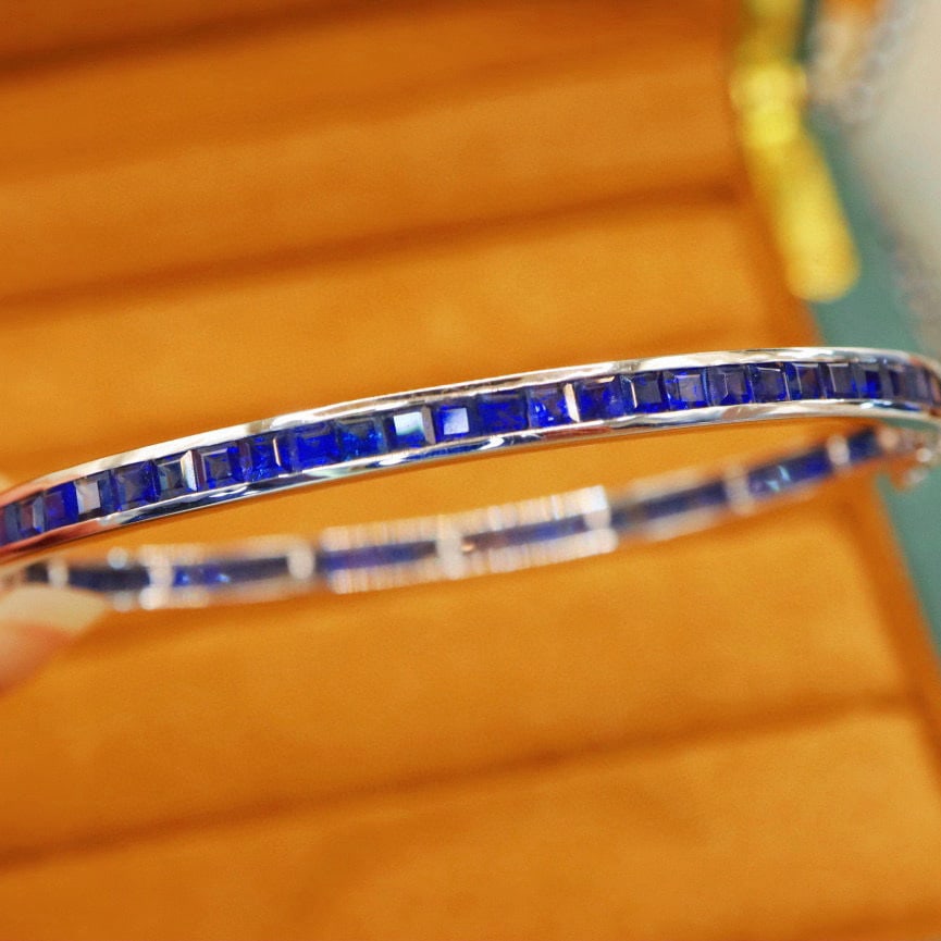 14k Gold 9.16 Ct Natural Sapphire Bangle: Ref:230976337 // gold content:14k gold // main gemstone:sapphire // shape:square // carat weight:9. 16ct // color:royal blue // treatment:natural // Condition: New Low Estimate: 10000.00 High