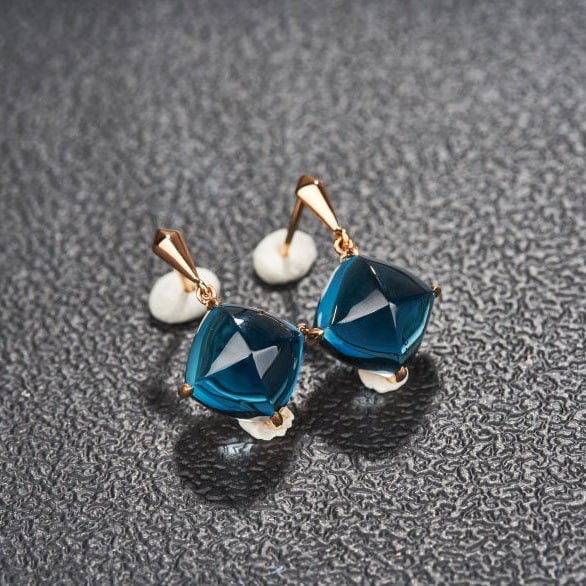14k Gold 15 Ct Natural Topaz Earrings: Ref:231151052 // gold content:14k gold // main gemstone:topaz // shape:sugar-loaf // carat weight:15ct // color:blue // treatment:natural // Low Estimate: 2400 Condition: New High Estimate: 3600