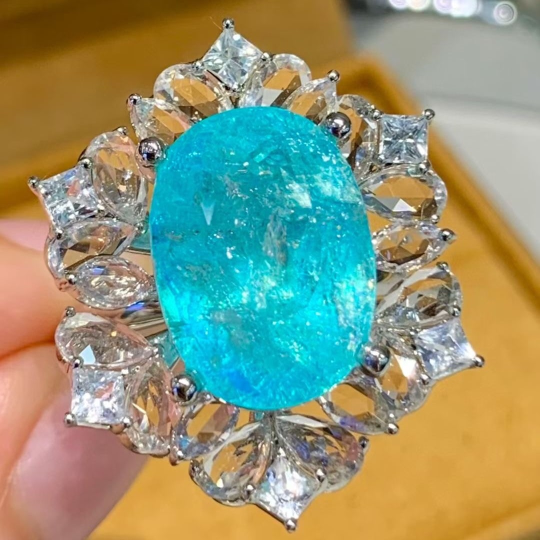 14k Gold 10.2 Ct Natural Paraiba Tourmaline & Sapphire Ring: Ref:231079046 // gold content:14k gold // ring size:7. 25 us // // main gemstone:paraiba tourmaline // shape:oval // carat weight:10. 2ct // color:neon blue // treatment:natural // // adjacent gemston