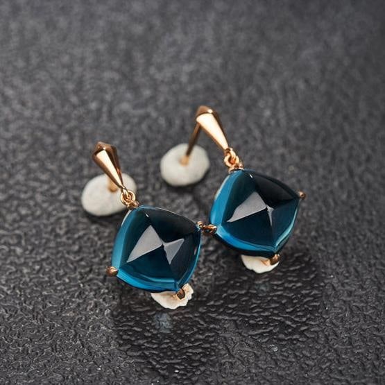 14k Gold 15 Ct Natural Topaz Earrings: Ref:231182281 // gold content:14k gold // main gemstone:topaz // shape:sugar-loaf // carat weight:15ct // color:blue // treatment:natural // Condition: New Low Estimate: 2200.00 High Estimate: 3300.00