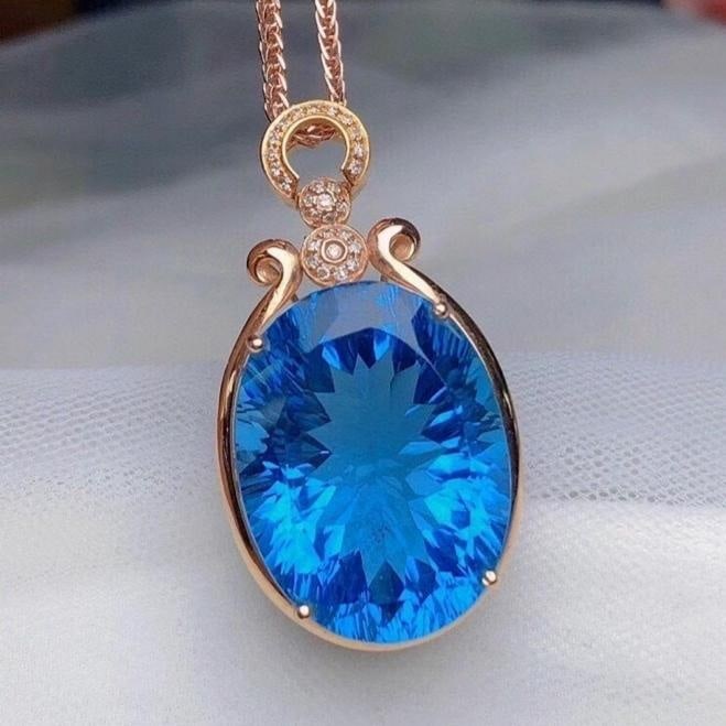 14k Gold 22.5 Ct Natural Topaz & Diamond Pendant( Without Chain ): Ref:231186100 // gold content:14k gold // main gemstone:topaz // shape:oval // carat weight:22. 5ct // color:blue // treatment:natural // // adjacent gemstone 2 : diamond // number of stones:27 //