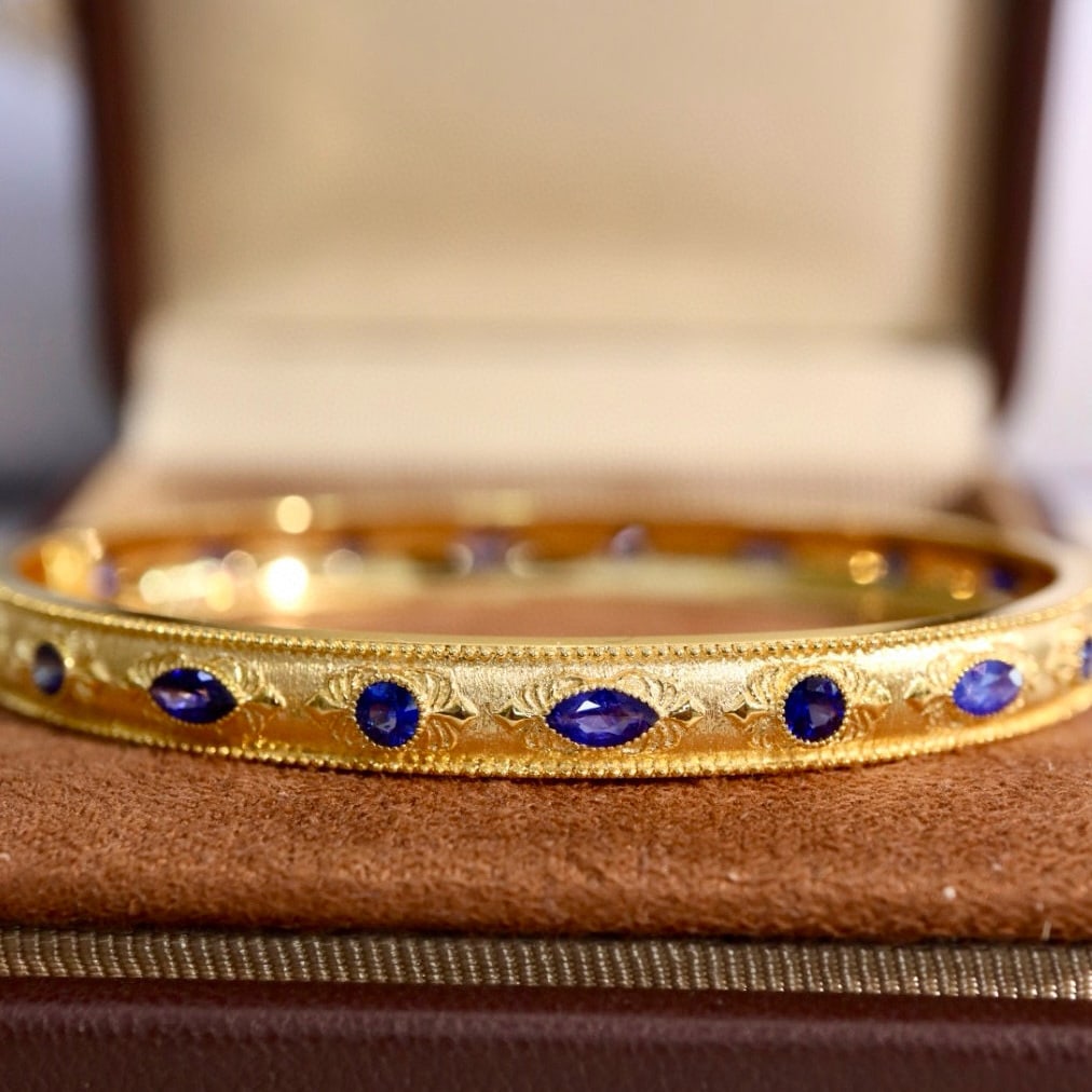 14k Gold 2.8 Ct Natural Sapphire Bangle: Ref:230958139 // gold content:14k gold // main gemstone:sapphire // shape:multiply // carat weight:2. 8ct // color:blue // treatment:natural // Condition: NewLow Estimate: 8400.00High Estimate: