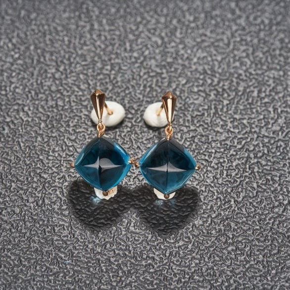 14k Gold 15 Ct Natural Topaz Earrings: Ref:231124025 // gold content:14k gold // main gemstone:topaz // shape:sugar-loaf // carat weight:15ct // color:blue // treatment:natural // Condition: NewLow Estimate: 2300.00High Estimate: 3400.00
