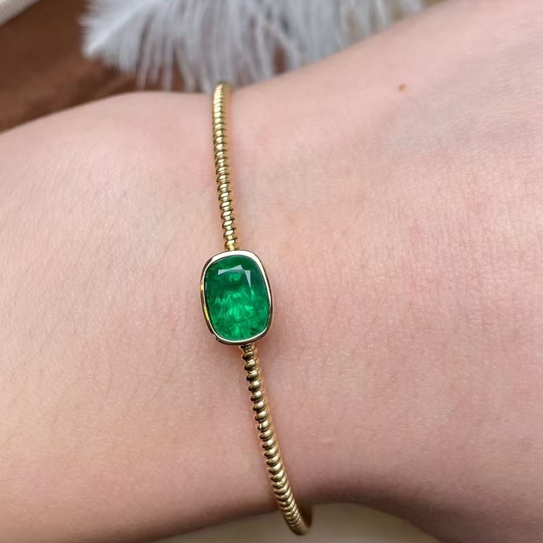 14k Gold 1.58 Ct Vivid Green Natural Emerald Bangle: Ref:230970182 // gold content:14k gold // main gemstone:emerald // shape:cushion // carat weight:1. 58ct // color:vivid green // treatment:natural // Condition: NewLow Estimate: 21000.00High