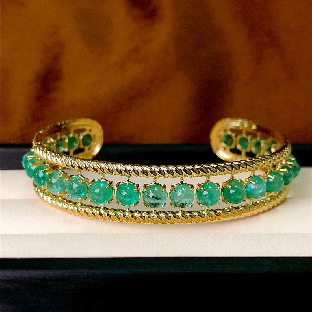 14k Gold 11.79 Ct Natural Emerald Bangle: Ref:230994131 // gold content:14k gold // main gemstone:emerald // shape:round // carat weight:11. 79ct // color:green // treatment:natural // cut grade:g // Condition: New Low Estimate: 8800 High