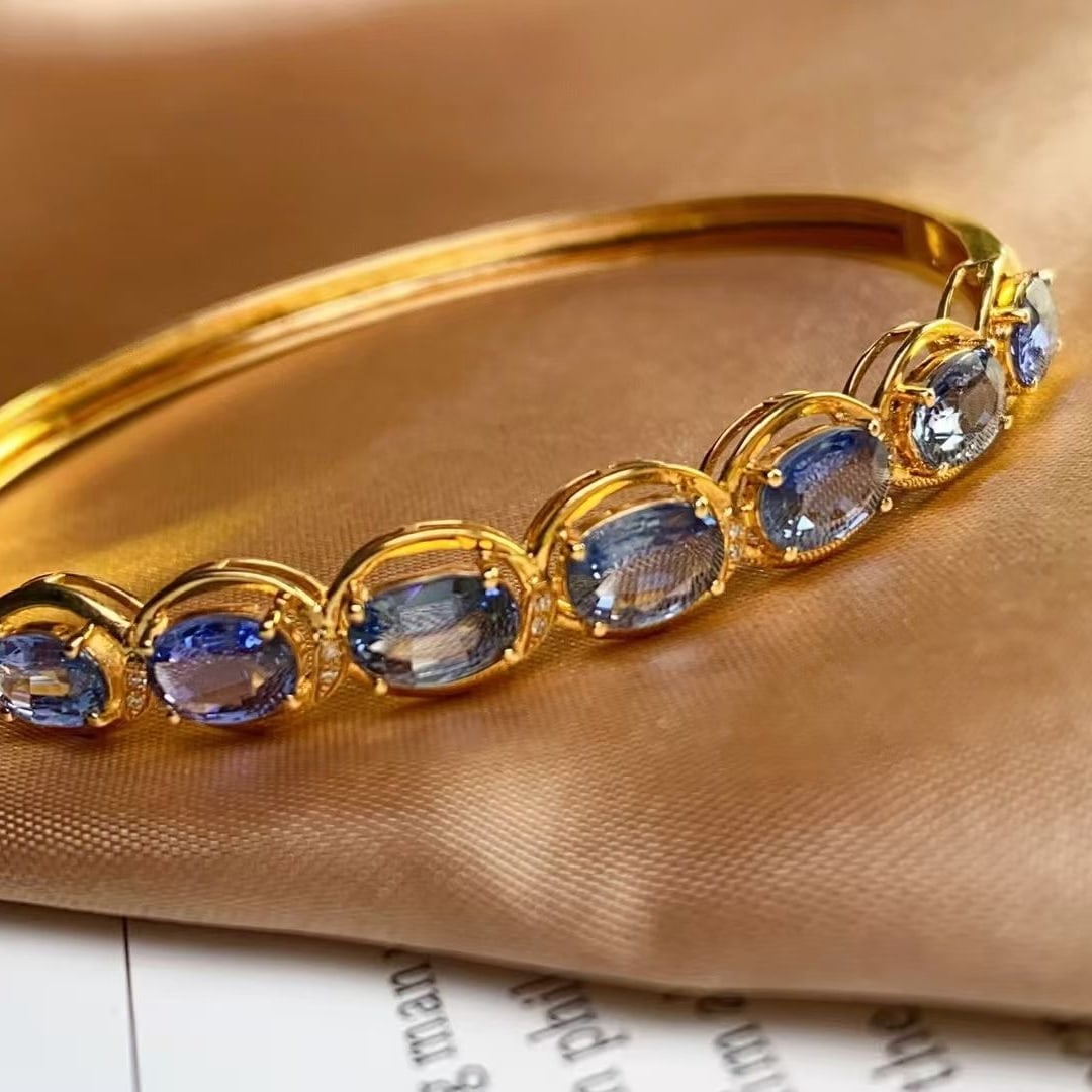 14k Gold 5.3 Ct Natural Sapphire & Diamond Bangle: Ref:230997220 // gold content:14k gold // main gemstone:sapphire // shape:oval // carat weight:5. 3ct // color:blue // treatment:natural // // adjacent gemstone 2 : diamond // number of stones:16 //