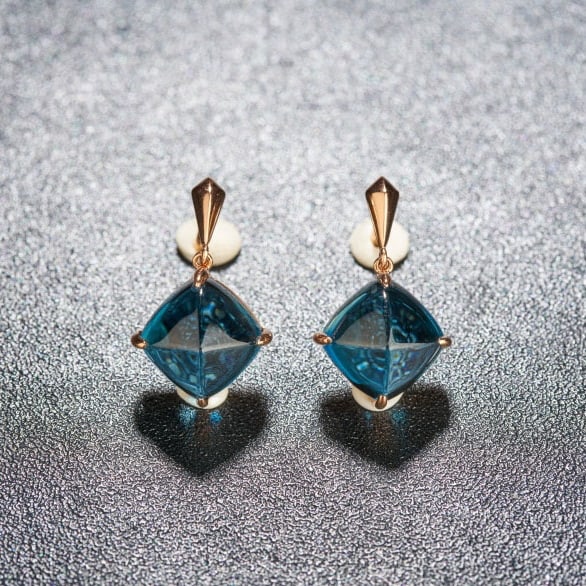 14k Gold 10.5 Ct Natural Topaz Earrings: Ref:231044033 // gold content:14k gold // main gemstone:topaz // shape:suger-loaf // carat weight:10. 5ct // color:blue // treatment:natural // Condition: New Low Estimate: 1900.00 High Estimate: