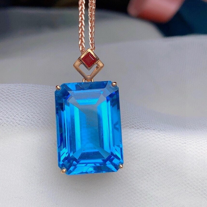 14k Gold 18.85 Ct Natural Topaz & Ruby Pendant( Without Chain ): Ref:231067243 // gold content:14k gold // main gemstone:topaz // shape:octagonal // carat weight:18. 85ct // color:blue // treatment:natural // // adjacent gemstone 2 : ruby // number of stones:1 //