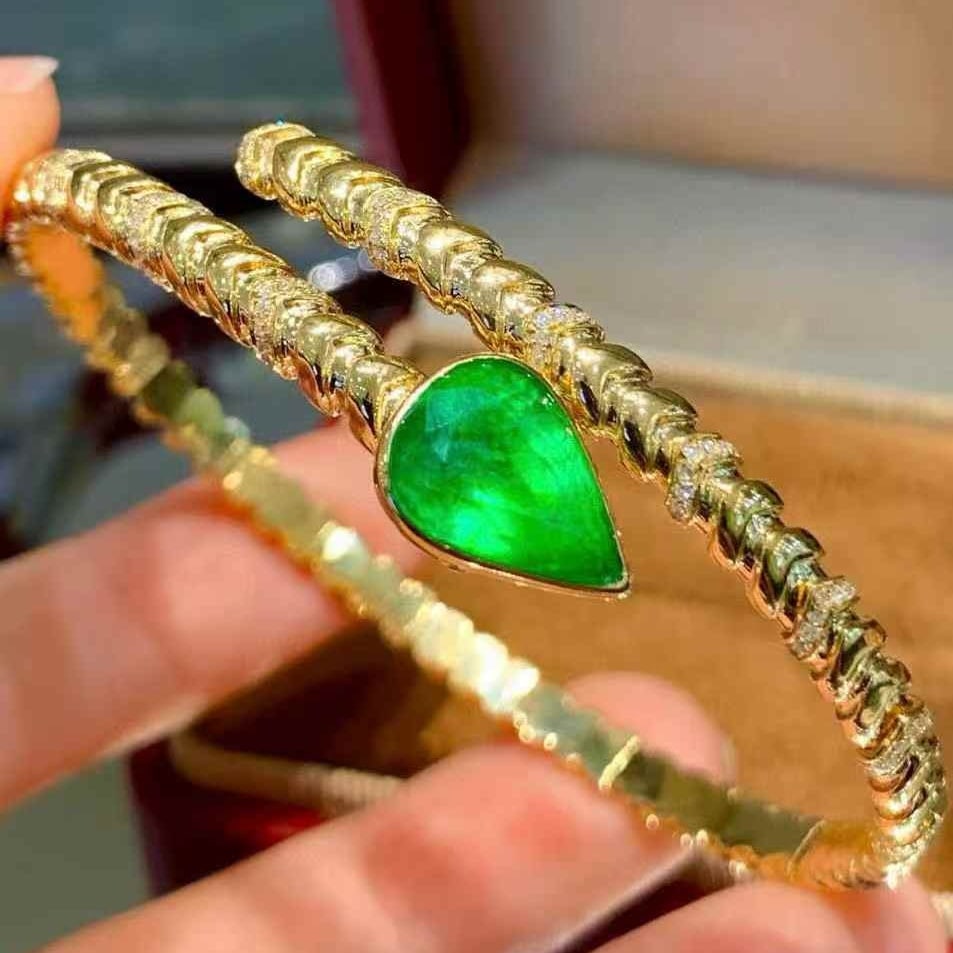 14k Gold 3.2 Ct Vivid Green Natural Emerald & Diamond Bangle: Ref:231081235 // gold content:14k gold // main gemstone:emerald // shape:octagonal // carat weight:3. 2ct // color:vivid green // treatment:natural // // adjacent gemstone 2 : diamond // shape:round