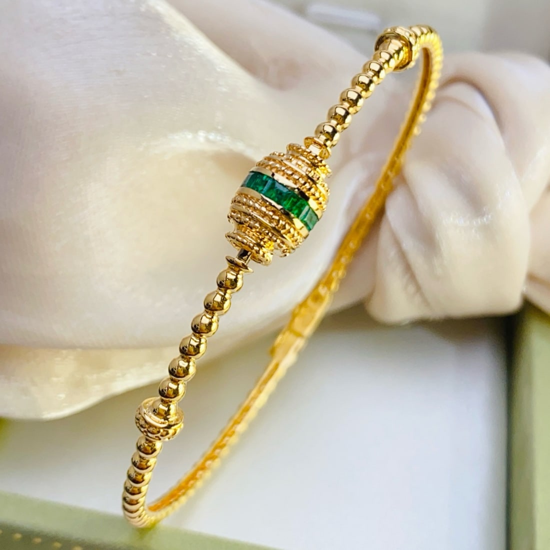 14k Gold 1.10 Ct Natural Emerald Bangle: Ref:231096107 // gold content:14k gold // main gemstone:emerald // shape:square // carat weight:1. 10ct // color:green // treatment:natural // Condition: New Low Estimate: 8400 High Estimate: 13000