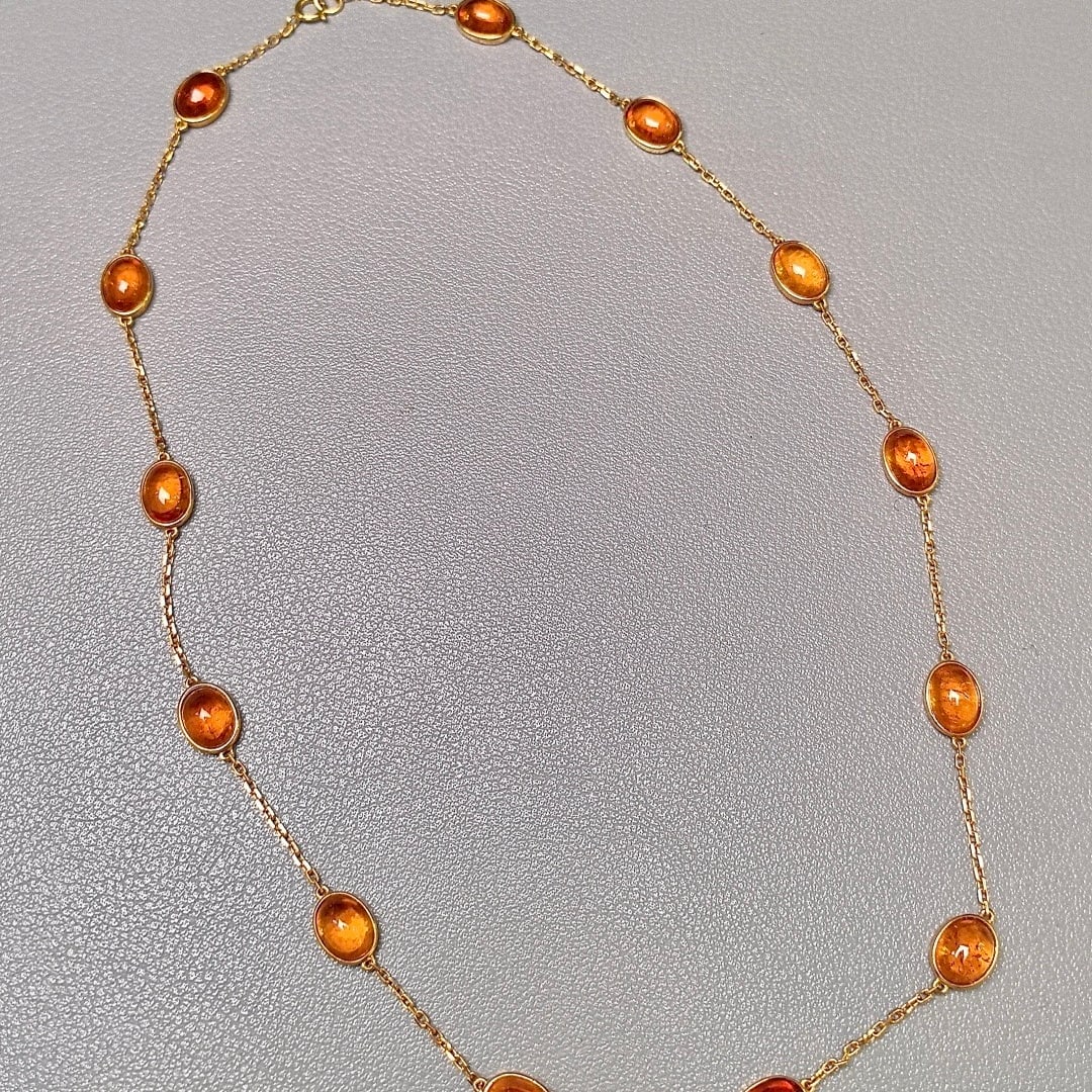 14k Gold 25.5 Ct Natural Spessartine Necklace: Ref:231108117 // gold content:14k gold // main gemstone:spessartine // shape:oval // carat weight:25. 5ct // color:orange // treatment:natural // Condition: New Low Estimate: 7300 High Estimate: 11000