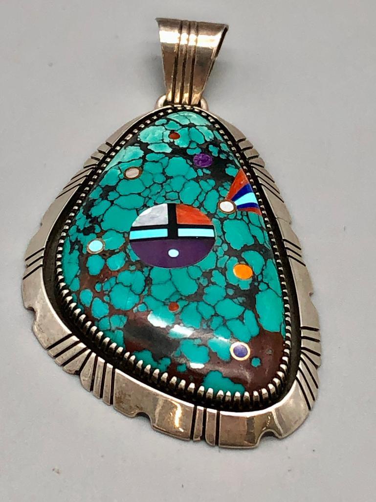 Turquoise and Inlay Pendant- Chester Benally: For your review is a turquoise and inlay pendant by Chester Benally. This pendant features a large turquoise cabochon in a handmade sawtooth silver bezel. The turquoise is accented with inlay of onyx,