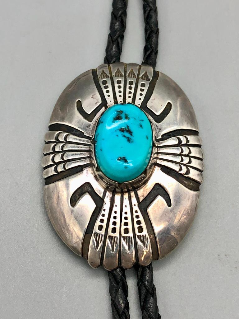 Tommy Singer Turquoise & Sterling Silver Bolo Tie: Available here for your consideration is a Tommy Singer turquoise and sterling silver bolo tie. The slide features a beautiful turquoise cabochon in a handmade bezel. The silver of the bolo is decorat