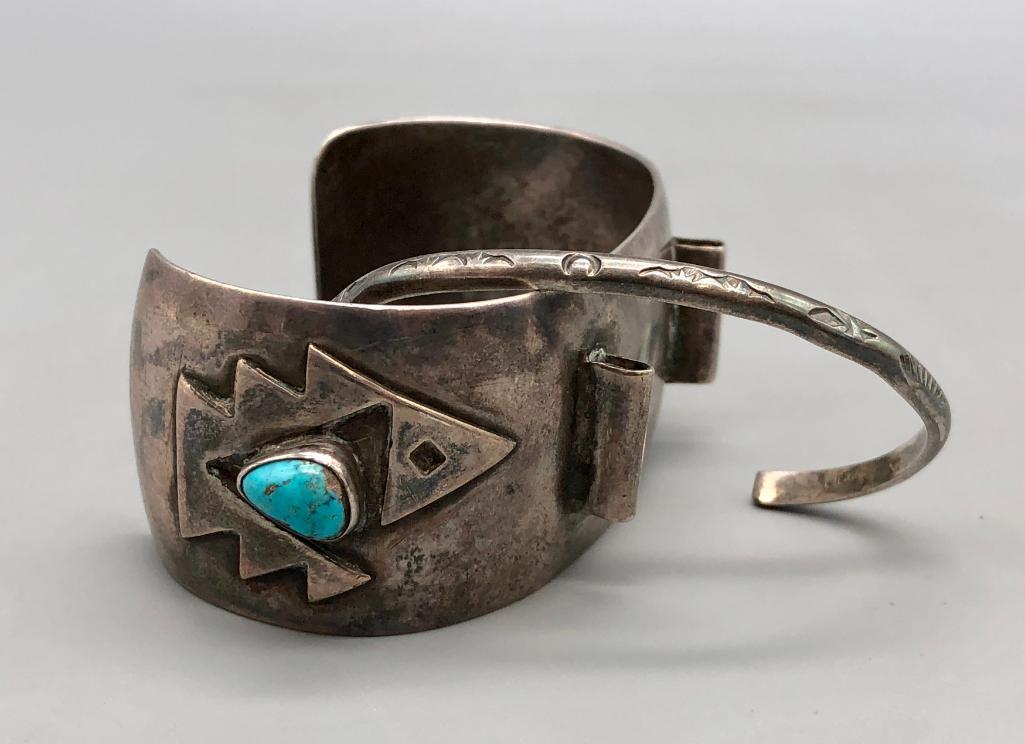 Vintage Turquoise Watch Cuff & Sterling Silver Bracelet: Available in this lot is a vintage watch cuff and sterling silver bracelet. This wonderful pair features a vintage watch cuff with two turquoise cabochons, and geometric silver designs on a thick ster
