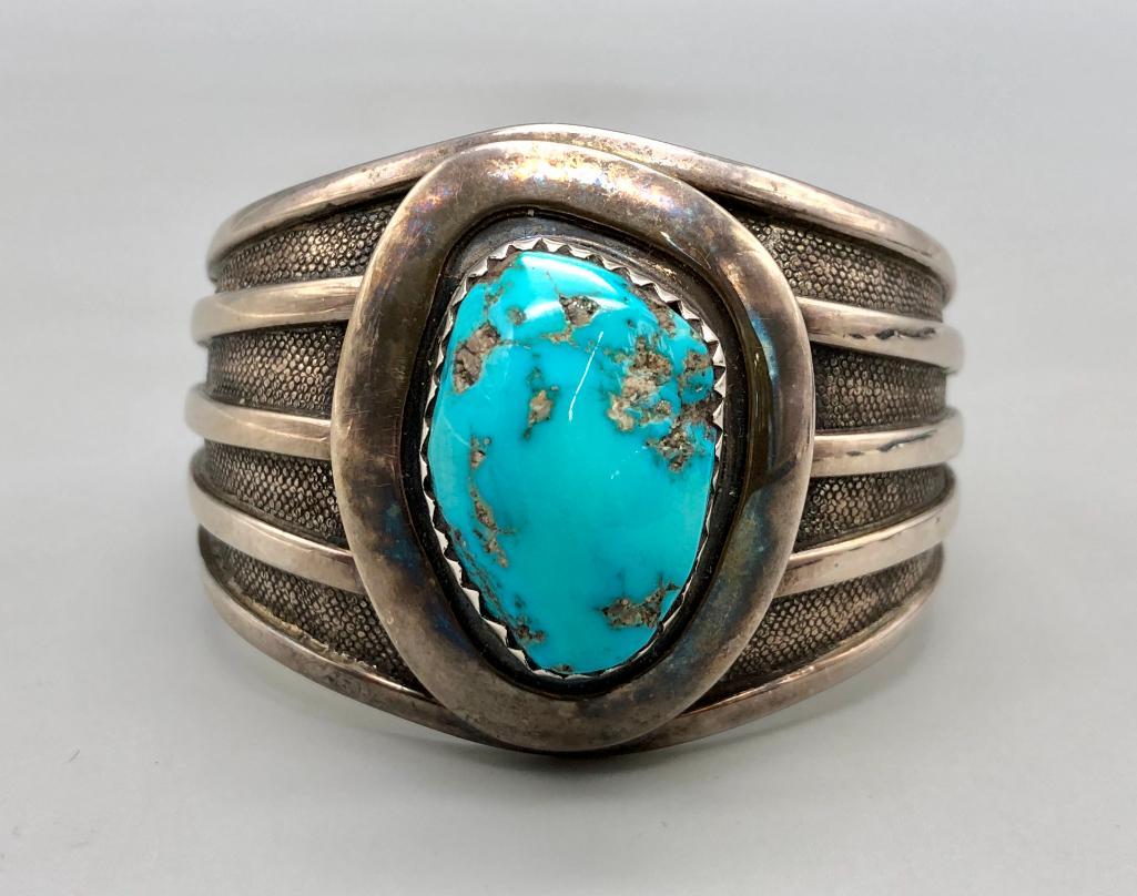 Turquoise & Sterling Silver Bracelet - Alberto Contreras: Offered in this lot is a turquoise and sterling silver bracelet by Contreras. This stunning bracelet features a larger turquoise cabochon in a sawtooth silver bezel on a smooth silver plate. The cuff 