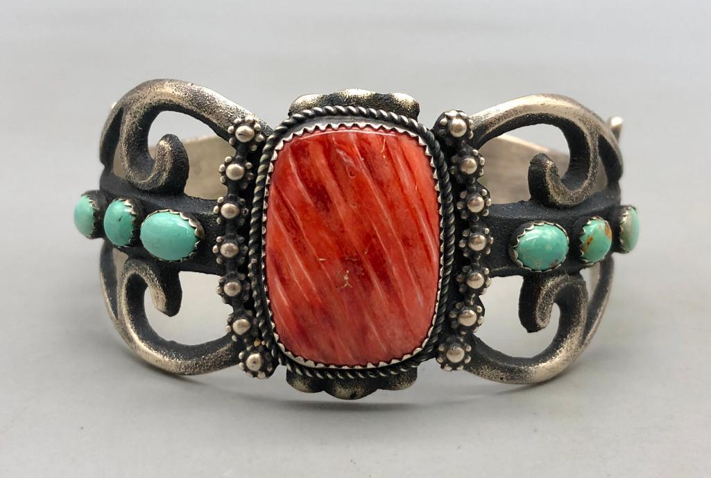 Spiny and Turquoise Bracelet by Alvin and Rose Boy: For your bidding is this spiny and turquoise bracelet. This gorgeous sandcast design centers a spiny cabochon in a sawtooth bezel surrounded by ornate silverwork. The sides grace three lovely turquois