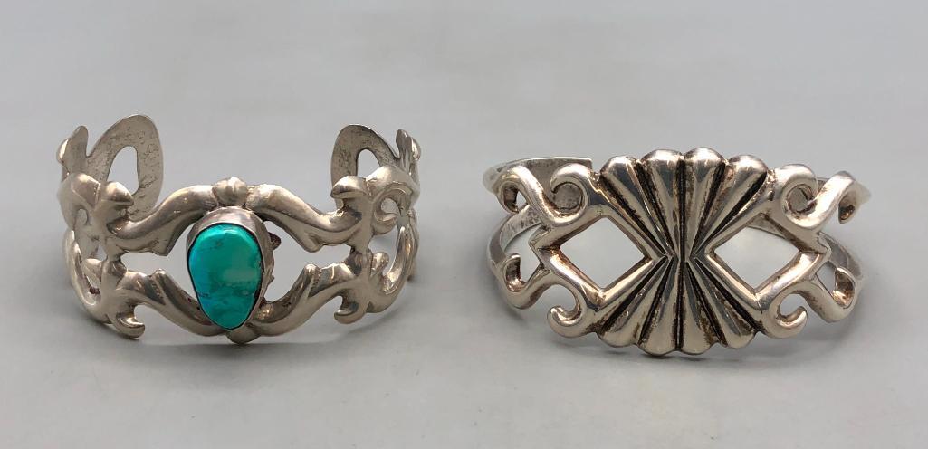 Two Sandcast Bracelets: Offered here are two sand cast bracelets. These exquisite pieces are sterling silver sandcast cuff bracelets, one with a turquoise cabochon at the center. The sandcast process uses a special type of s
