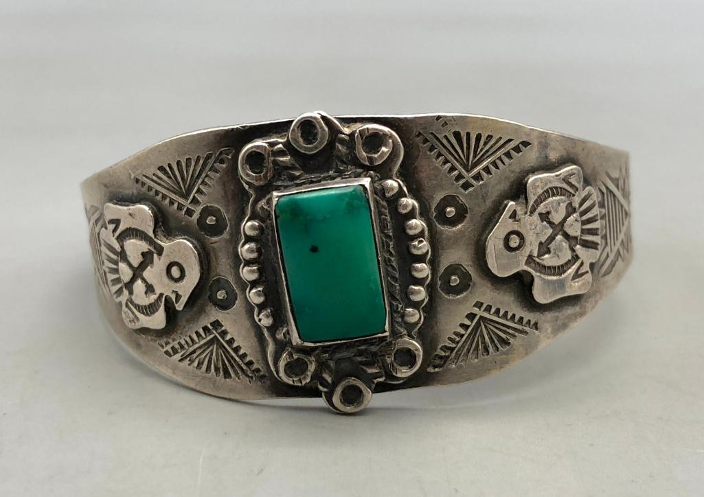 Fred Harvey Era Turquoise Bracelet: A bracelet to consider is this Fred Harvey era turquoise bracelet. Featuring intricate stamping and silver applique, its a step back in time! A vibrant turquoise cabochon is at the center, surrounded 