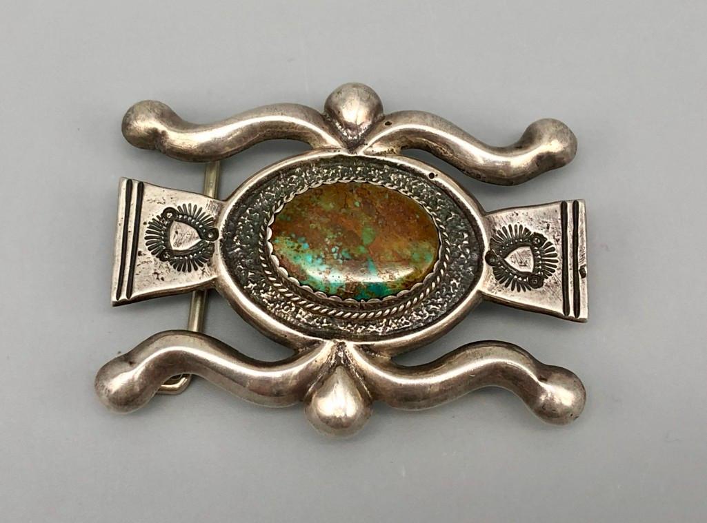 Splendid Sandcast Turquoise and Sterling Silver Buckle: Offered for your consideration is a beautiful Navajo sandcast belt buckle. It is set with a great green turquoise cabochon flowing with beautiful brown matrix, placed in a handmade sawtooth bezel. The