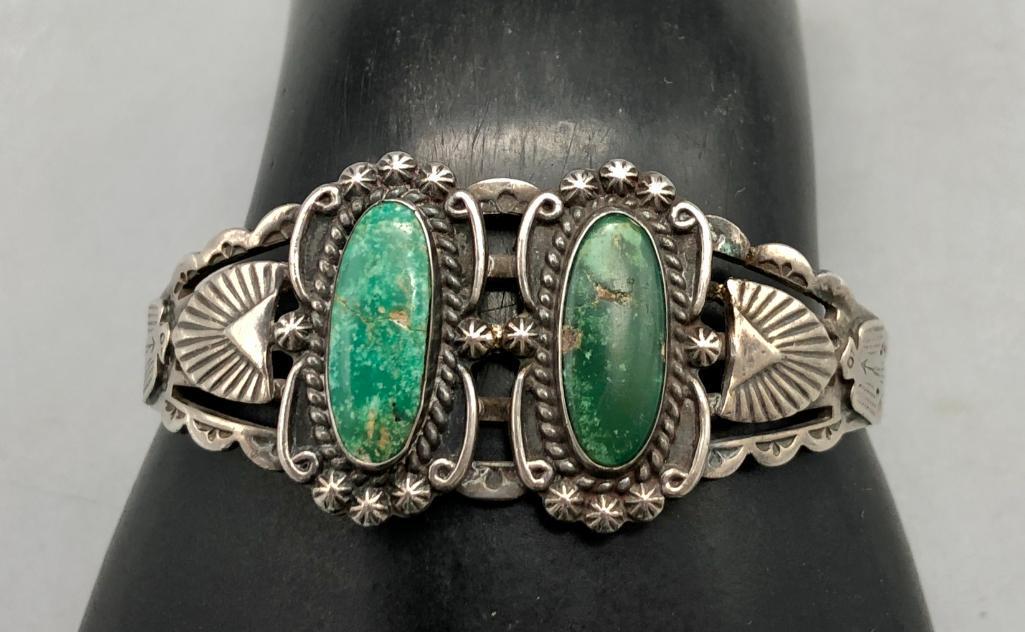 Fred Harvey Era Turquoise Bracelet: Offered here is a Fred Harvey turquoise bracelet. This lovely piece features two green turquoise cabochons on a great hand stamped and silver cutout band. Add this Fred Harvey piece to your collection
