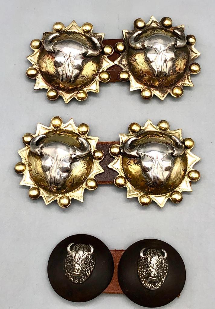Three Pairs of Buffalo Themed Conchos: Offered here for your consideration are three pairs of buffalo themed concho's. One pair is silver on iron while the other two feature silver buffalo skulls on a brass background. The backs are a scre