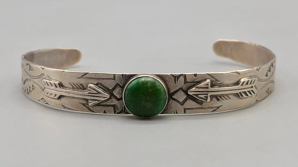 1920s-1930s Era Sterling Silver and Turquoise Bracelet: Offered in this lot is a 1920s-1930s era sterling silver and turquoise bracelet. This stunning bracelet has a smaller green turquoise cabochon, in a handmade silver bezel. Silverwork of arrow applique