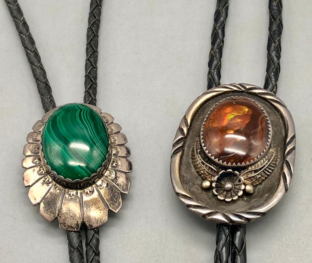 Vintage Tigers Eye And Malachite Bolo Ties: Offered in this lot are vintage Tigers Eye and malachite bolo ties. The Tigers Eye slide has a beautiful cabochon resting in a sawtooth bezel accented with silver dots (raised and flattened)