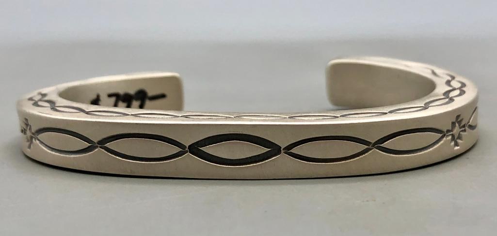 Hefty Stamped Sterling Silver Bracelet by Ron Tom: For your bidding enjoyment we present a hefty stamped sterling silver bracelet by Ron Tom. This bracelet features a very heavy smooth silver cuff bracelet with very nice deep hand stamped designs on t