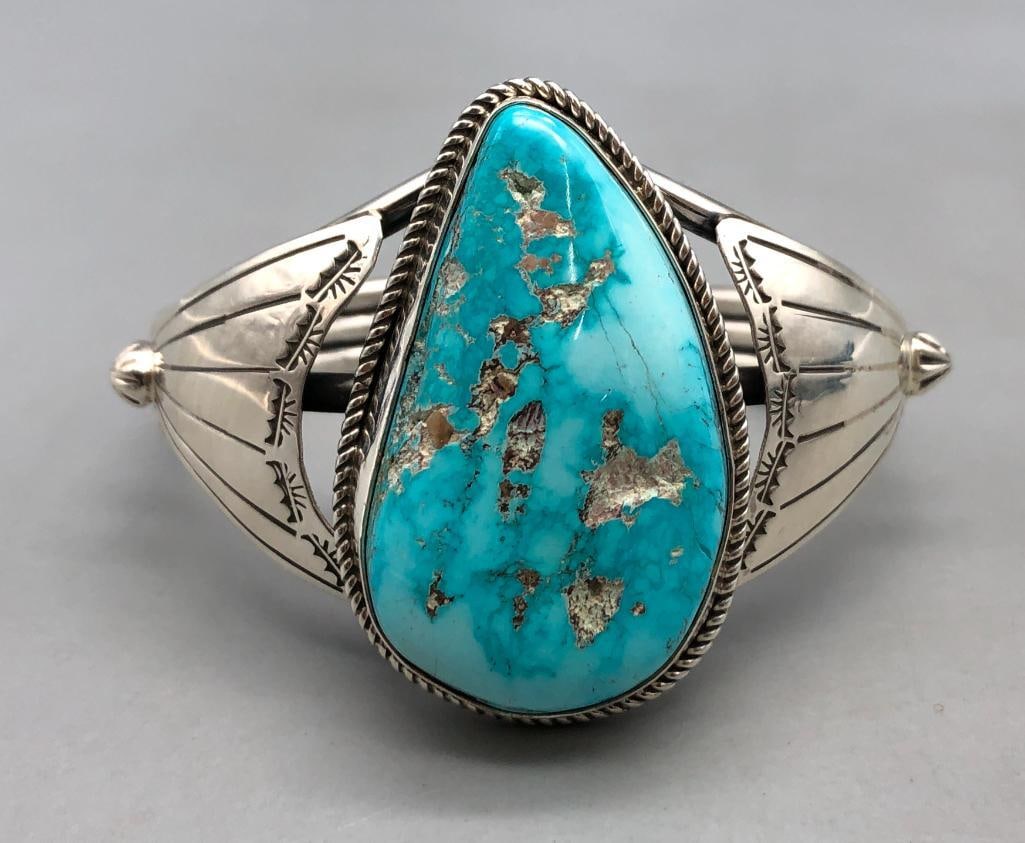 Nice Turquoise Sterling Silver Bracelet By Larose Ganadonegro: For your bidding enjoyment we present a nice turquoise sterling silver bracelet by Larose Ganadonegro. This bracelet features a large central turquoise cabochon resting in a smooth silver bezel surrou
