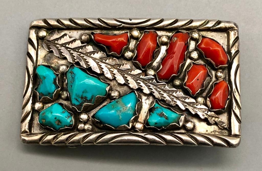 Vintage Zuni Turquoise And Coral Belt Buckle: Available here in this lot is a vintage Zuni turquoise and coral belt buckle. This sterling silver belt buckle features five turquoise and six coral cabochons resting in handmade silver bezels, and di