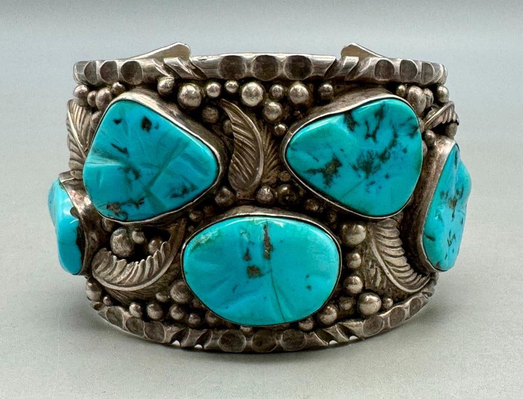 Hefty Seven Stone Turquoise Bracelet: For your bidding enjoyment we present a hefty seven stone turquoise bracelet. This bracelet features seven lovely blue turquoise nugget style cabochons resting in smooth silver bezels accented with si