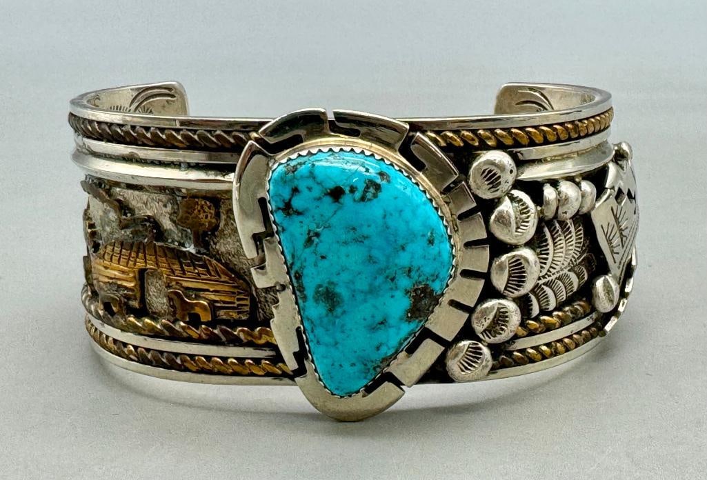 Hefty Storyteller Turquoise Bracelet: For your bidding enjoyment we present a hefty storyteller turquoise bracelet. This bracelet features a central turquoise cabochon resting in a handmade sawtooth bezel surrounded by a silver overlay de