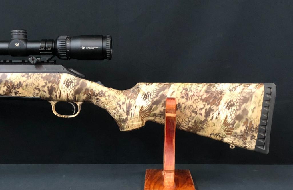 Ruger American Bolt Action Rifle: For your bidding pleasure is a Ruger American Bolt Action Rifle chambered in 5.56 NATO. It has a camouflaged synthetic stock, a threaded barrel, and is equipped with a Vortex 3x9x40 Crossfire scope. T