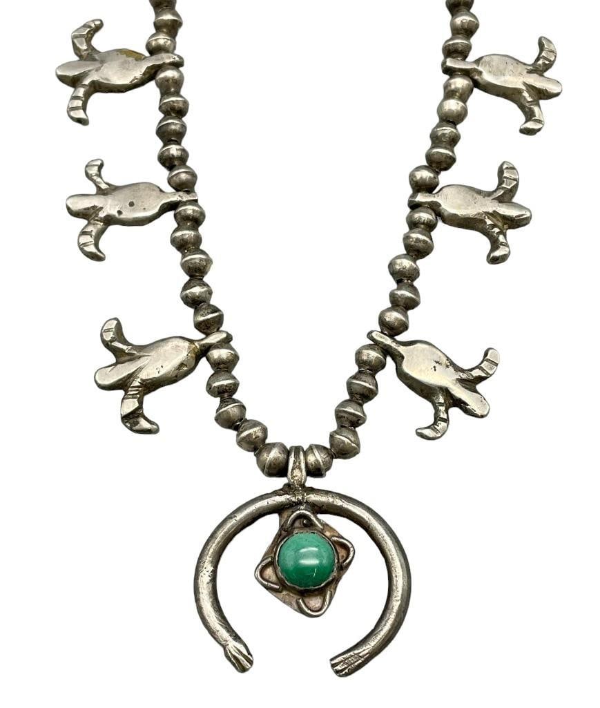 Old Ingot Handmade Fleur De Lis Style Squash Blossom Necklace: Offered here for your consideration is an old ingot handmade Fleur De Lis style squash blossom necklace. This necklace features a hand stamped naja highlighted with one central green turquoise cabocho