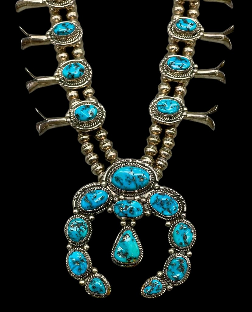 Turquoise Squash Blossom Necklace By Wilson Padilla: Offered here for your consideration is a turquoise squash blossom necklace by Wilson Padilla. This squash blossom necklace showcases a striking naja pendant adorned with eleven turquoise cabochons in 