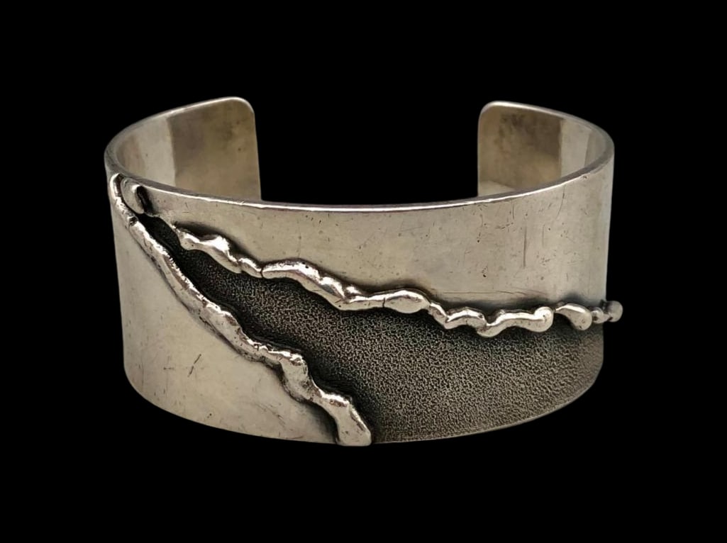 Stylized Fred Skaggs Sterling Silver Bracelet: For your bidding enjoyment we present a stylized Fred Skaggs sterling silver bracelet. This bracelet features a smooth silver cuff with raised silver line designs creating a triangular shape with inte