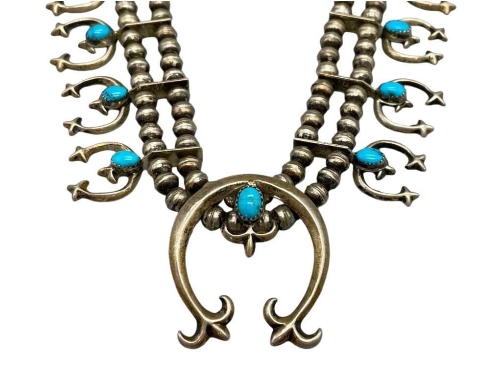 Fleur De Lis Style Squash Blossom Necklace: Offered here for your consideration is a Fleur De Lis style squash blossom necklace. This necklace features a tab style naja highlighted with one blue turquoise cabochon resting in a handmade sa