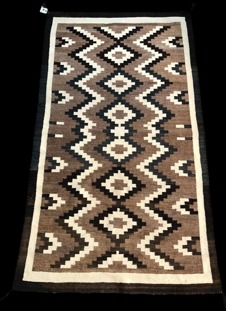 Vintage Earth Toned Navajo Rug: Available here for your consideration is a vintage earth toned Navajo rug. This rug features a great chevron design bordering a row of diamond designs down the center. The designs are done in black an