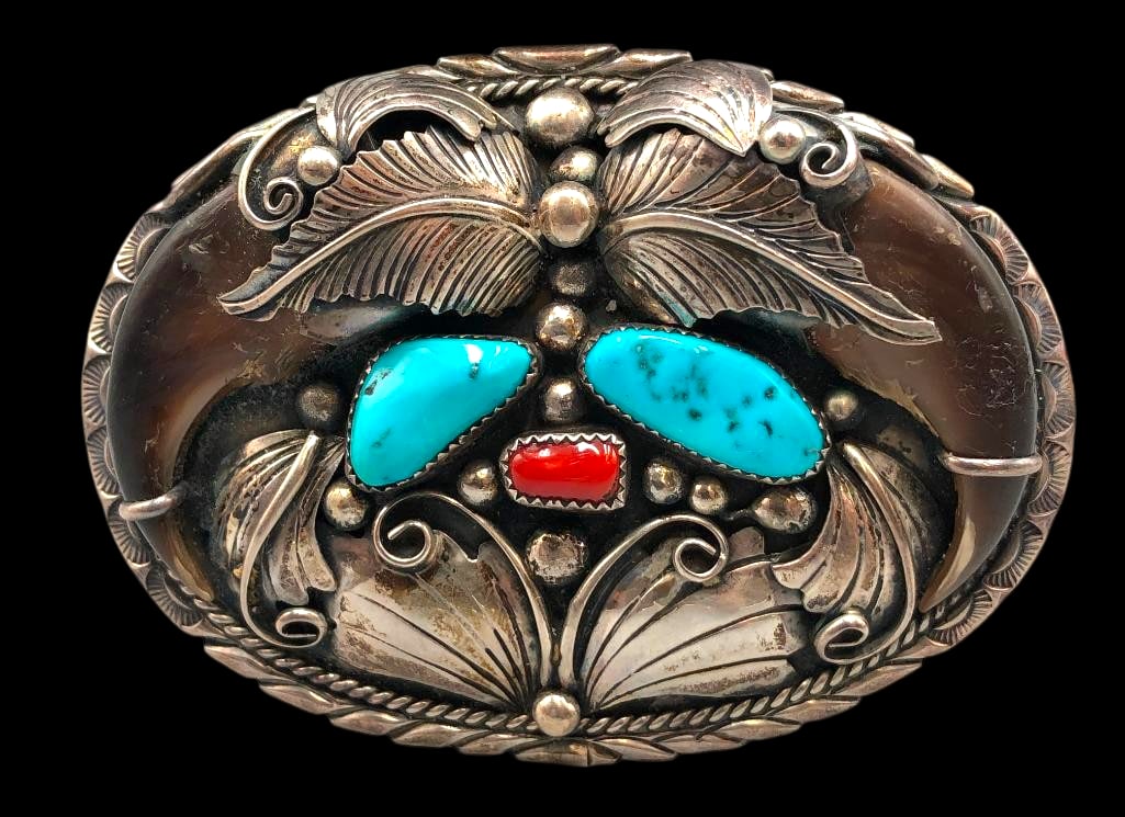 Turquoise, Coral And Claw Belt Buckle: Available here in this lot is a turquoise, coral and claw belt buckle. This sterling silver belt buckle is highlighted with two bear claws, two turquoise cabochons and one coral cabochon each resting