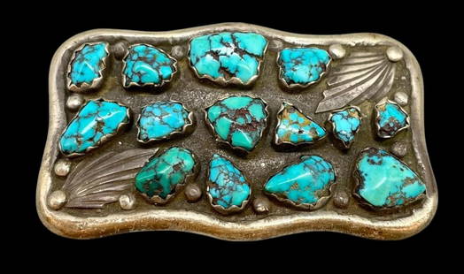 14 Stone Turquoise And Sterling Silver Belt Buckle: Available here in this lot is a 14 stone turquoise and sterling silver belt buckle. This sterling silver belt buckle features 14 turquoise cabochons resting in scalloped silver bezels. The design is a