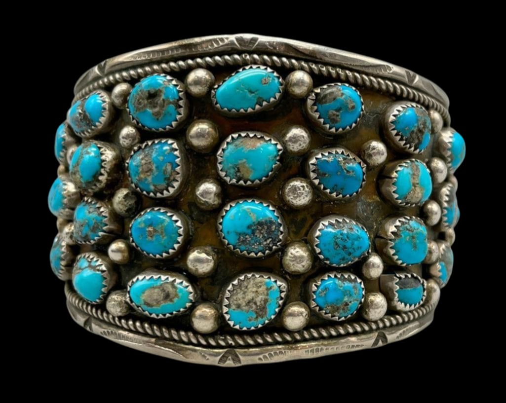 Vintage Turquoise Cluster Bracelet: Available here in this lot is a vintage turquoise cluster bracelet. This smooth sterling silver cuff features a lovely cluster of 36 turquoise cabochons resting in sawtooth bezels accented by silver d