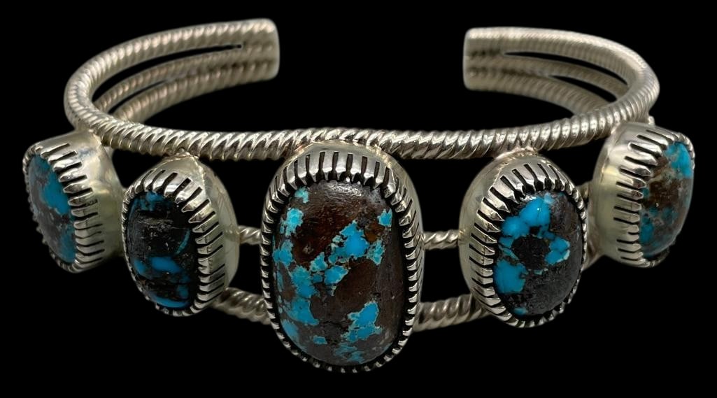 High Grade Turquoise Bracelet By Lyndon Tsosie: Offered here for your consideration is a high grade turquoise and sterling silver bracelet by multiple award winning artist Lyndon Tsosie. This cuff features five turquoise cabochons set in handmade s
