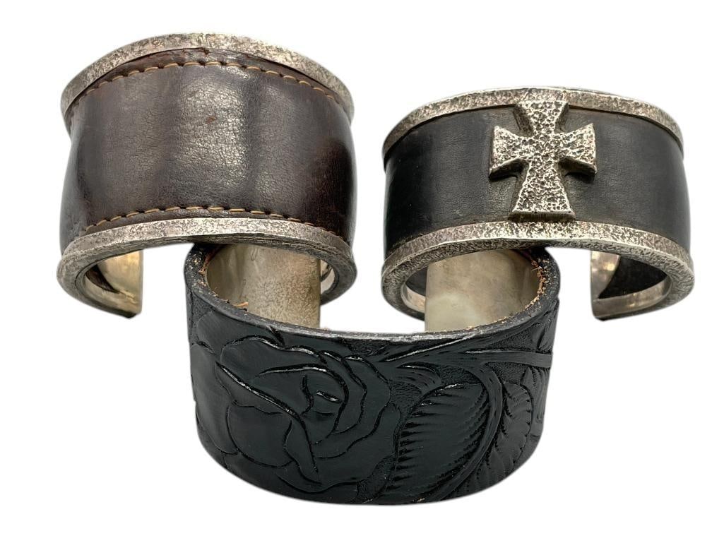 Three Leather And Sterling Silver Bracelets: Available here for your consideration is a group of three leather and sterling silver bracelets. Each bracelet features leather inlay framed with sterling silver, one accented with a central silver cr