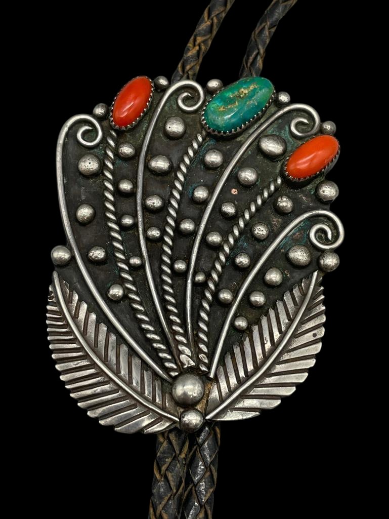 Vintage Unique Style Turquoise Coral And Sterling Silver Bolo Tie: Offered here in this lot is a vintage unique style turquoise, coral and sterling silver bolo tie. The flower design slide features one turquoise and two coral cabochons resting in handmade sawtooth be